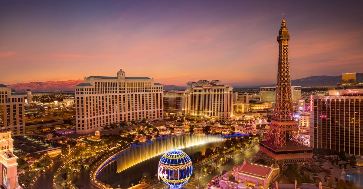 Stunning aerial view of Las Vegas skyline at sunset, featuring the Eiffel Tower and Bellagio fountains.