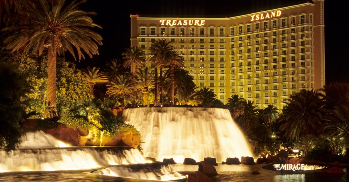 A stunning nighttime view of Treasure Island Hotel and waterfall in Las Vegas, perfect for travel and tourism visuals.