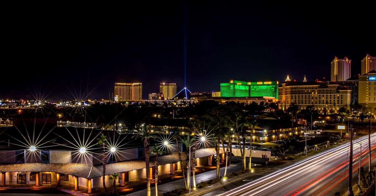 Dynamic night view of Las Vegas Strip with glowing hotels and bustling light trails.